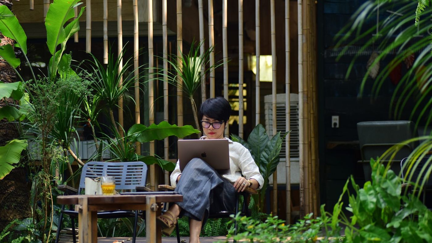 Arbeiten am Laptop zwischen tropischen Pflanzen