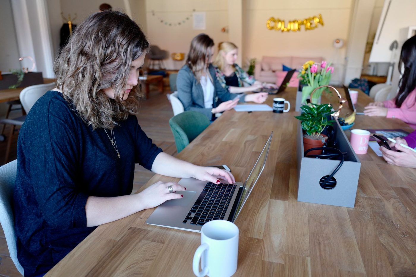 Coworking an einem langen Holztisch