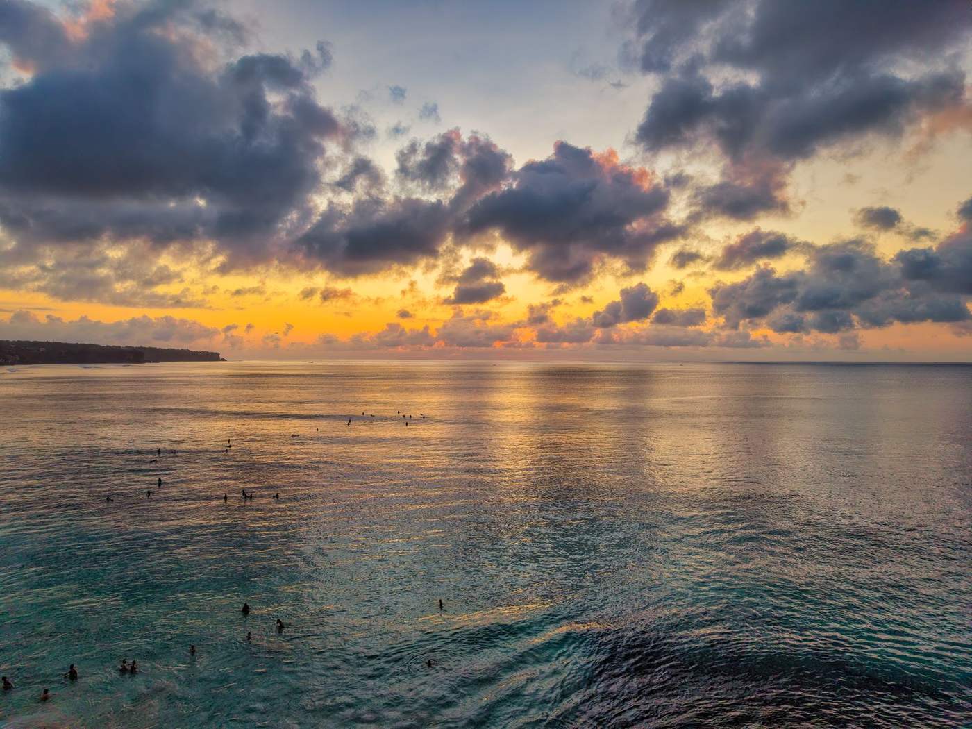 Sonnenuntergang über dem Meer mit Surfern auf Bali